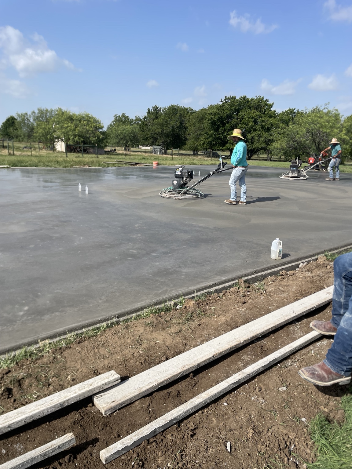 Crew finishing fresh concrete with power trowels